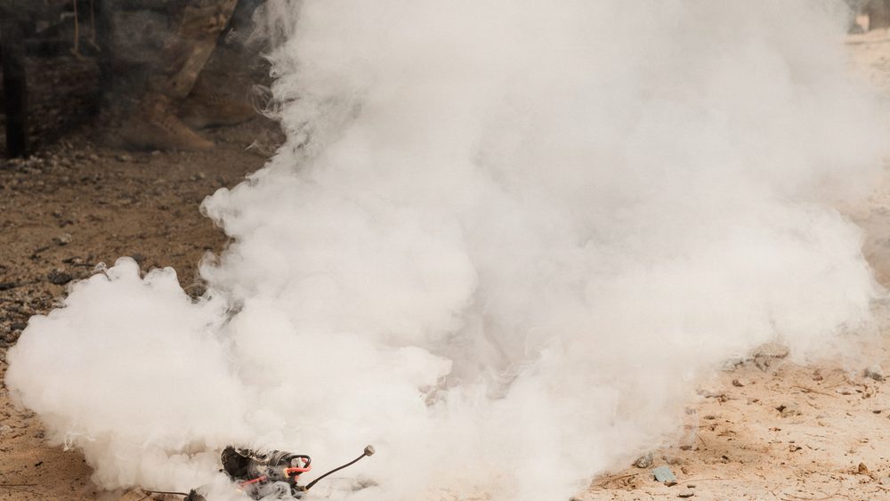 A small unmanned aerial system is destroyed in a cloud of white smoke after being struck during counter-sUAS training