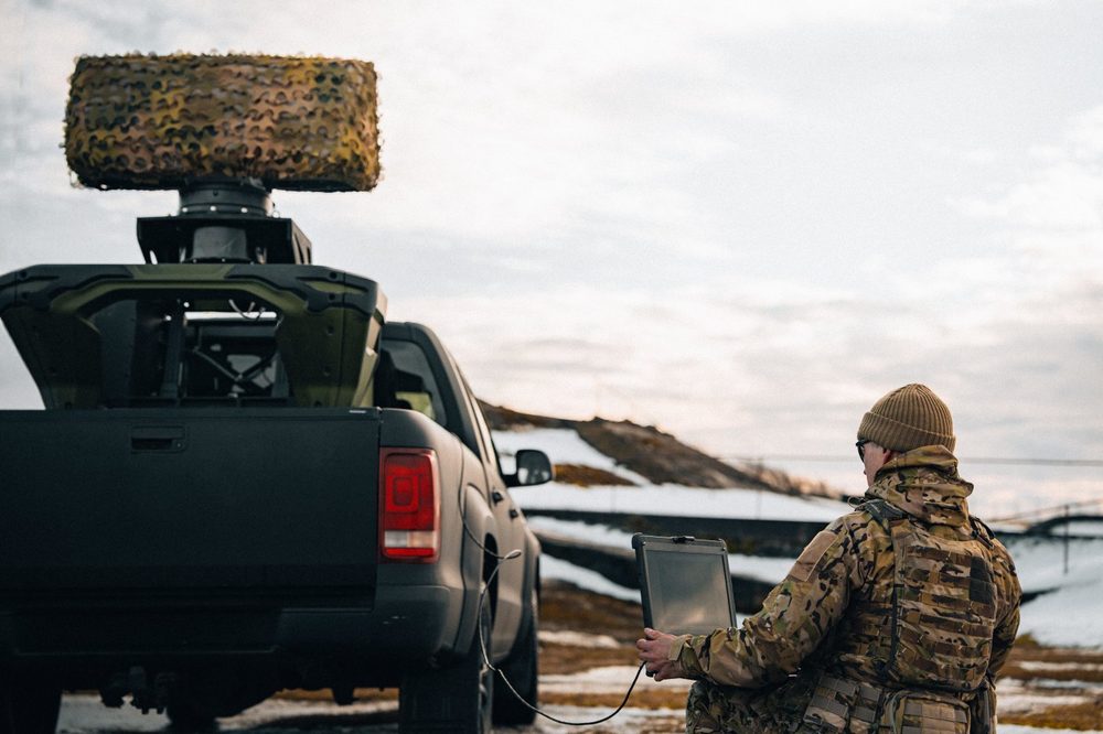 Soldier operating Saab Giraffe 1X radar via tablet C2 interface, with radar mounted on pickup truck in Nordic winter conditions