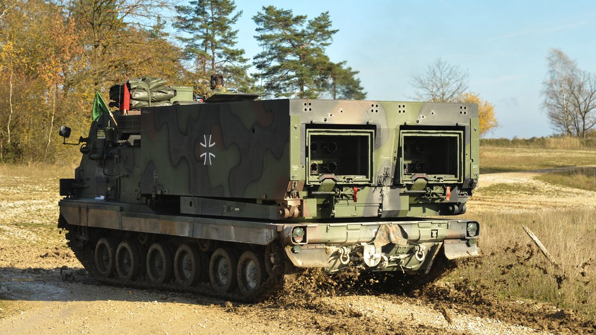 Bundeswehr MARS (M270 MLRS) tracked launcher at Grafenwoehr Training Area with Iron Cross marking and Bundeswehr pennant visible
