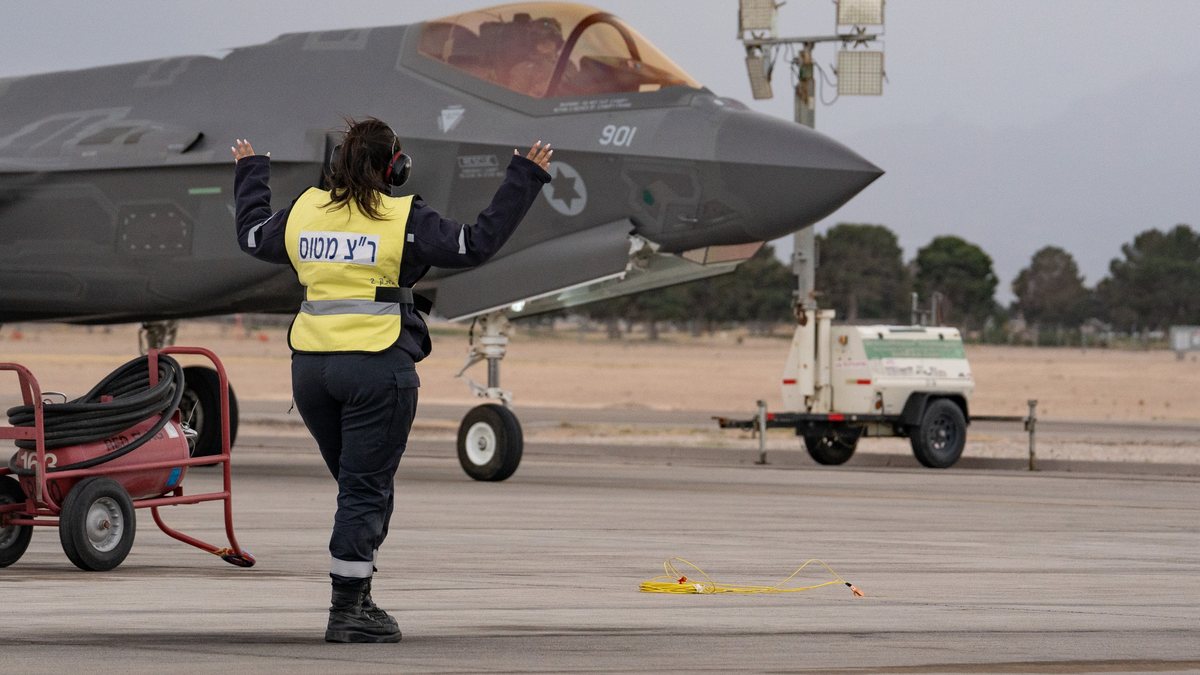 An Israeli Air Force ground crew member marshals an F-35I Adir of Squadron 140 (Golden Eagle), tail number 901, on the ramp at Nellis Air Force Base, Nevada.