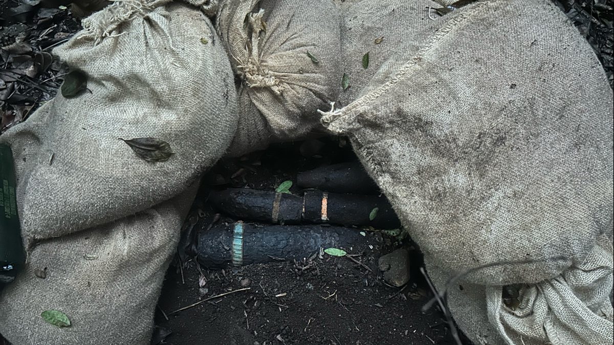 A partially buried munition stabilised with sandbags before controlled detonation at Makua Military Reservation, Hawaii