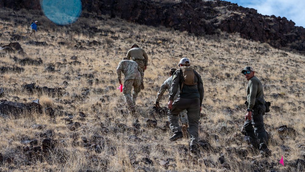 EOD teams cross rugged terrain during the Pueblo of Acoma WWII ordnance clearance.