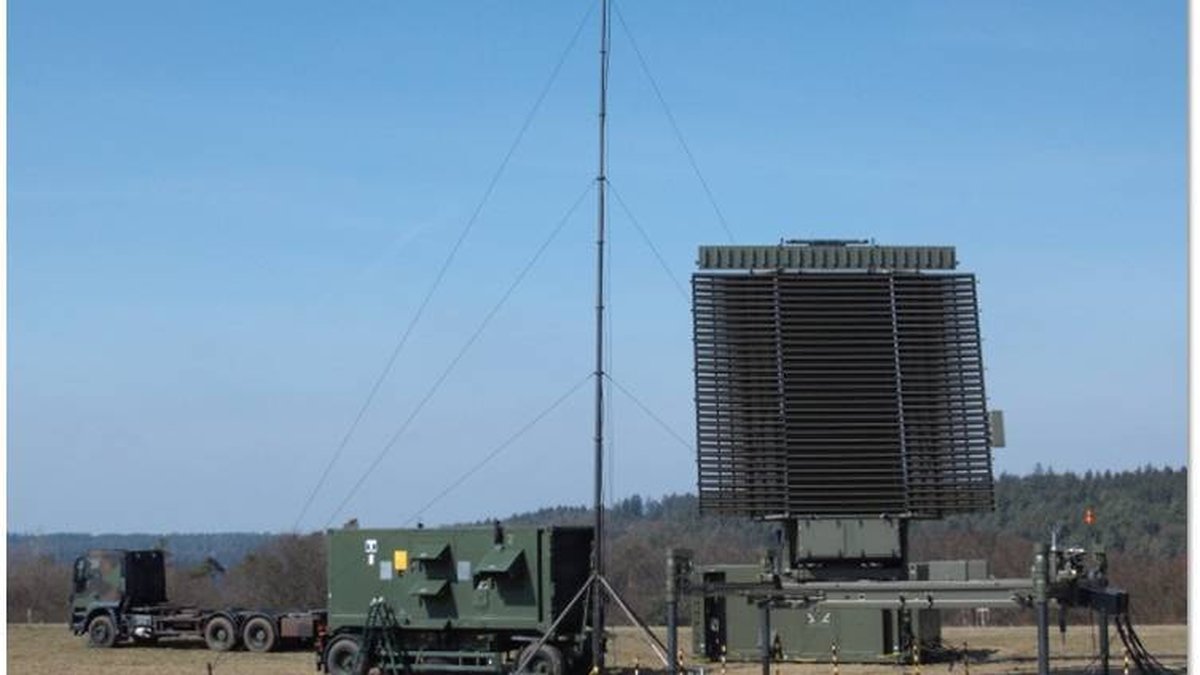 Leonardo RAT-31DL/M deployable L-band air-defence radar in the field, rotating planar array raised on its mast beside the transport vehicles
