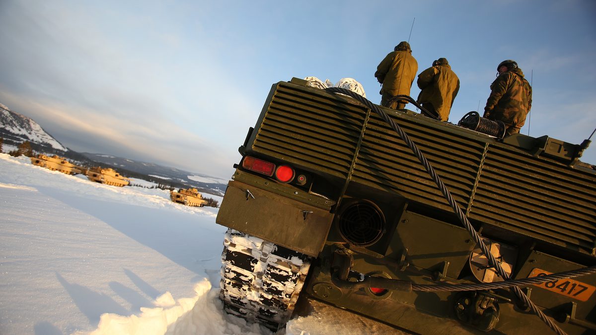 Abrams and Leopard 2 main battle tanks fire on a combined NATO live-fire range, sharing the 120 mm smooth-bore round.